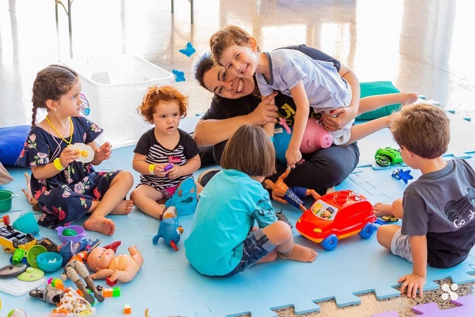 Kids playing on the floor with a volunteer at the kids ministry